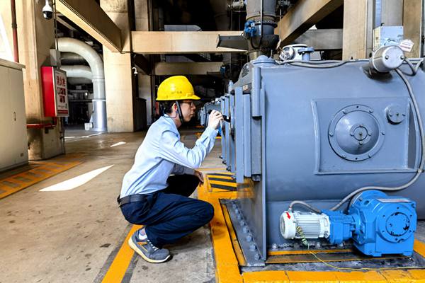 圖為運(yùn)行人員巡視檢查給煤機(jī)清掃鏈條運(yùn)行情況